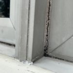 Old cracked window caulking with cracks, causing this window to leak and cause wood rot.