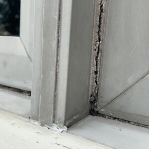 Old cracked window caulking with causing this window to leak and cause wood rot.